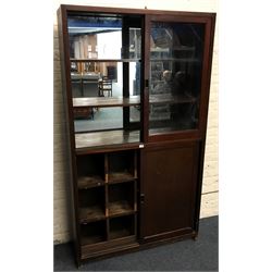 20th century pine mirror back display cabinet with sliding glass doors revealing two shelves, above solid sliding doors revealing fitted interior, platform base 