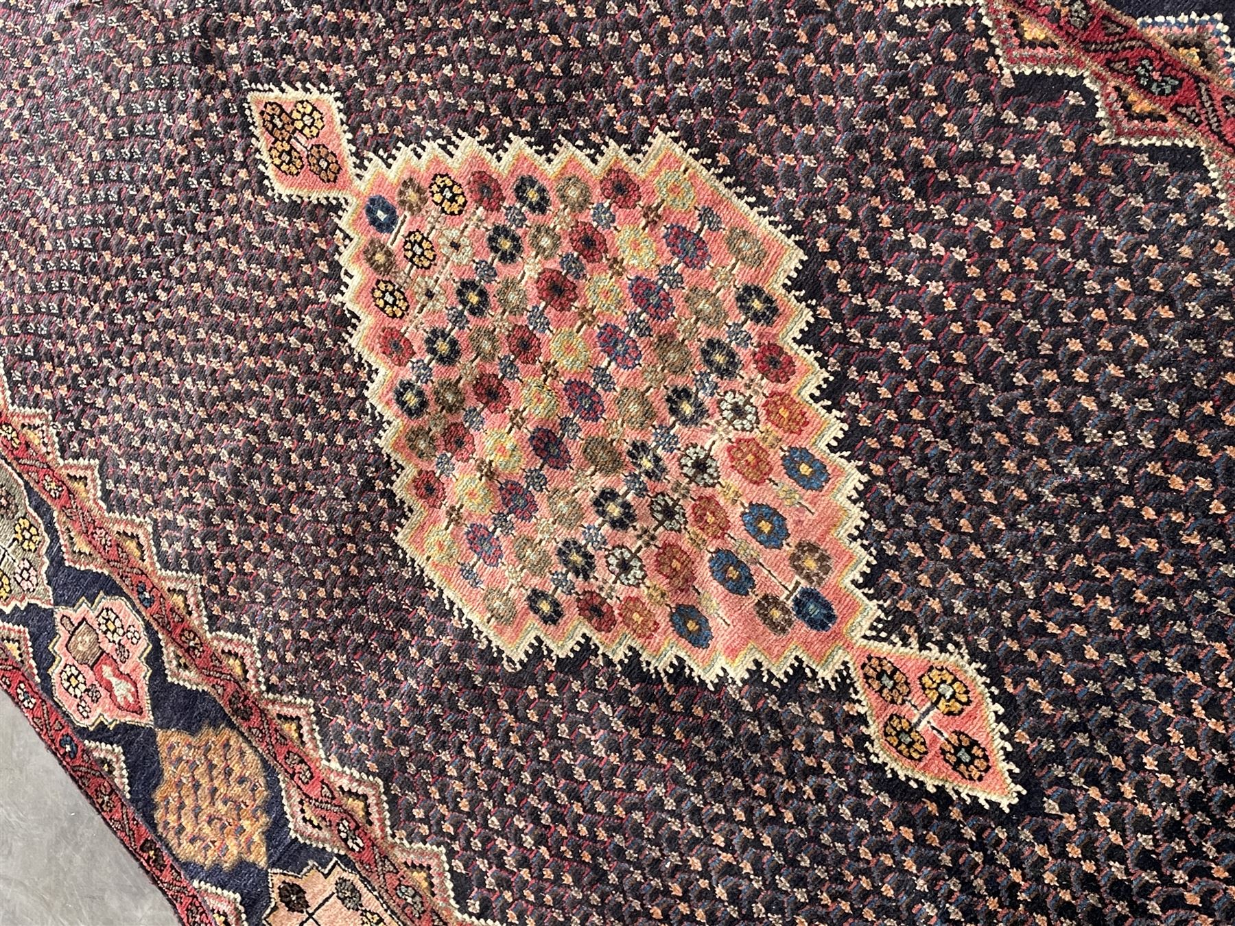 Persian Hamadan blue ground rug, medallion on field decorated with repeating motifs, the guarded border with multiple medallions decorated with flower heads and stylised motifs