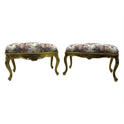 Pair of Louis XV-design giltwood stools, each upholstered in floral tapestry fabric, the carved frame adorned with scrolling foliage and shell motifs, raised on cabriole supports