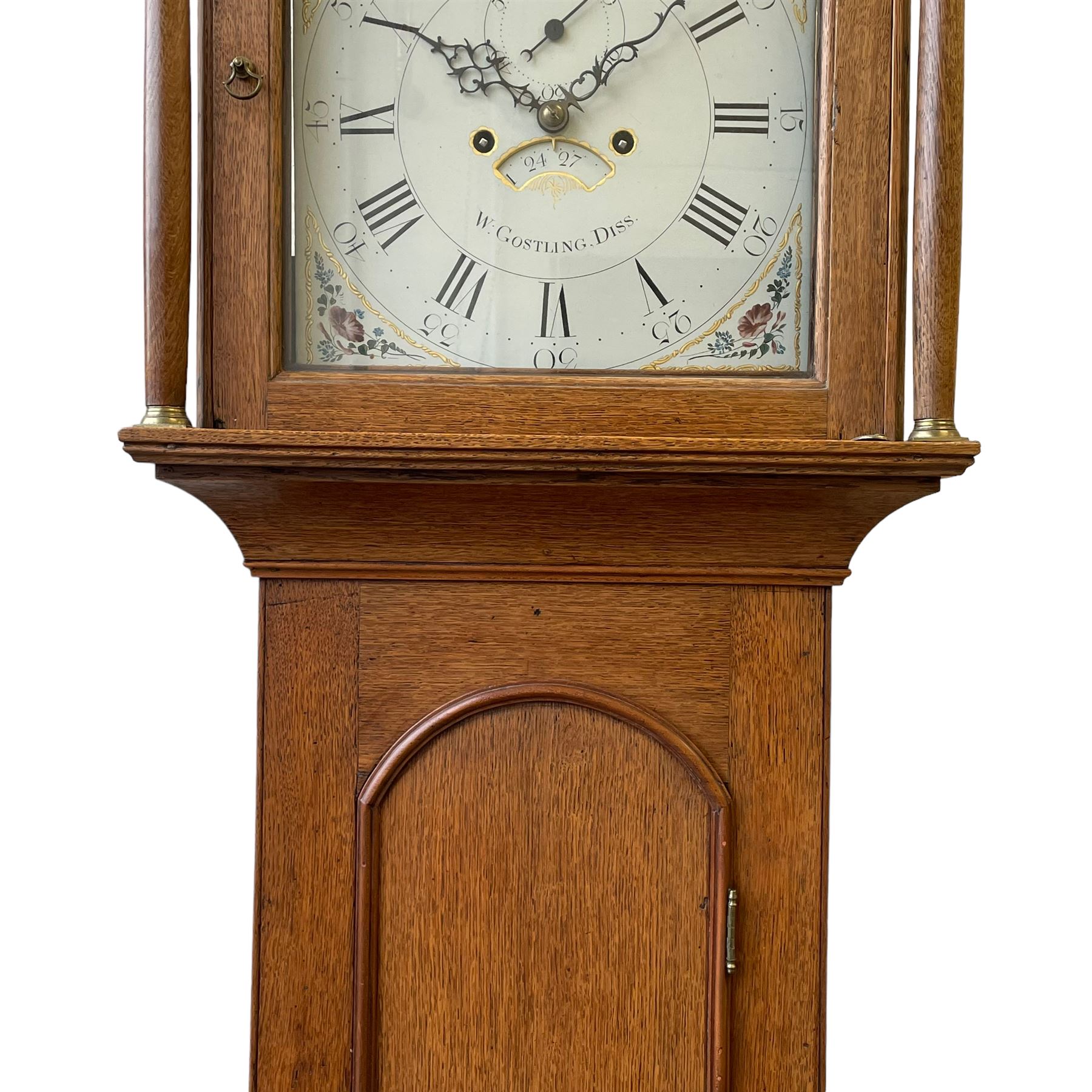 William Gostling of Diss  (Norfolk)-  Late 18th century 8-day oak longcase clock c1780-90, break arch top with scalloped cresting and three brass finials, glazed break arch hood door flanked by turned pilasters with brass capitals, trunk with a long trunk door and rounded top on a square plinth with an applied and shaped skirting, early painted Wilson of Birmingham dial with Roman numerals and five minute Arabic's, matching steel hands and second pointer, arched square ended calendar aperture with date disc behind, floral spandrels within gesso borders and a painted rocking automaton representing Mercury to the break arch, dial pinned via a false plate to a weight driven rack striking movement with a recoil anchor escapement, striking the hours on a cast bell. With pendulum weights and key. 
William Gostling (II) is recorded as working in Diss from 1774 to 1797, succeeded by widow Anne and son George . The dial of this clock is illustrated and discussed in detail in M.F. Tennants book 