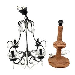 Terracotta studio pottery lamp base with carved detail and geometric knop and base, H45cm, together with a black chandelier with drops, Mid century teak light fitting with three drop down clear glass pendants and copper mounts, H54cm, and Rhinestone and black eight branched chandelier