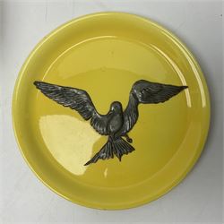 Early 20th century brown glazed bowl, decorated with slip type decoration of flowers, together with a Park Lane Ware yellow plate with applied pewter bird decoration