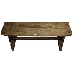 Late Victorian ecclesiastical pitch pine side table, rectangular bow-front top, on shaped end supports pierced with quatrefoils, united by pegged stretcher 