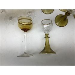Set of nine German or Dutch Roemer glasses raised on olive coloured tapering spiral stem foot, the bowls with gilt upper rim, H16cm, together with five amber coloured glasses with gilt banding