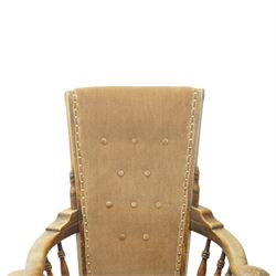 Near pair of late 20th century oak high back armchair, upholstered in brown fabric with buttoned back and close-nailed borders, shaped arms on turned supports, over a stuff-over seat, raised on turned legs united by stretchers