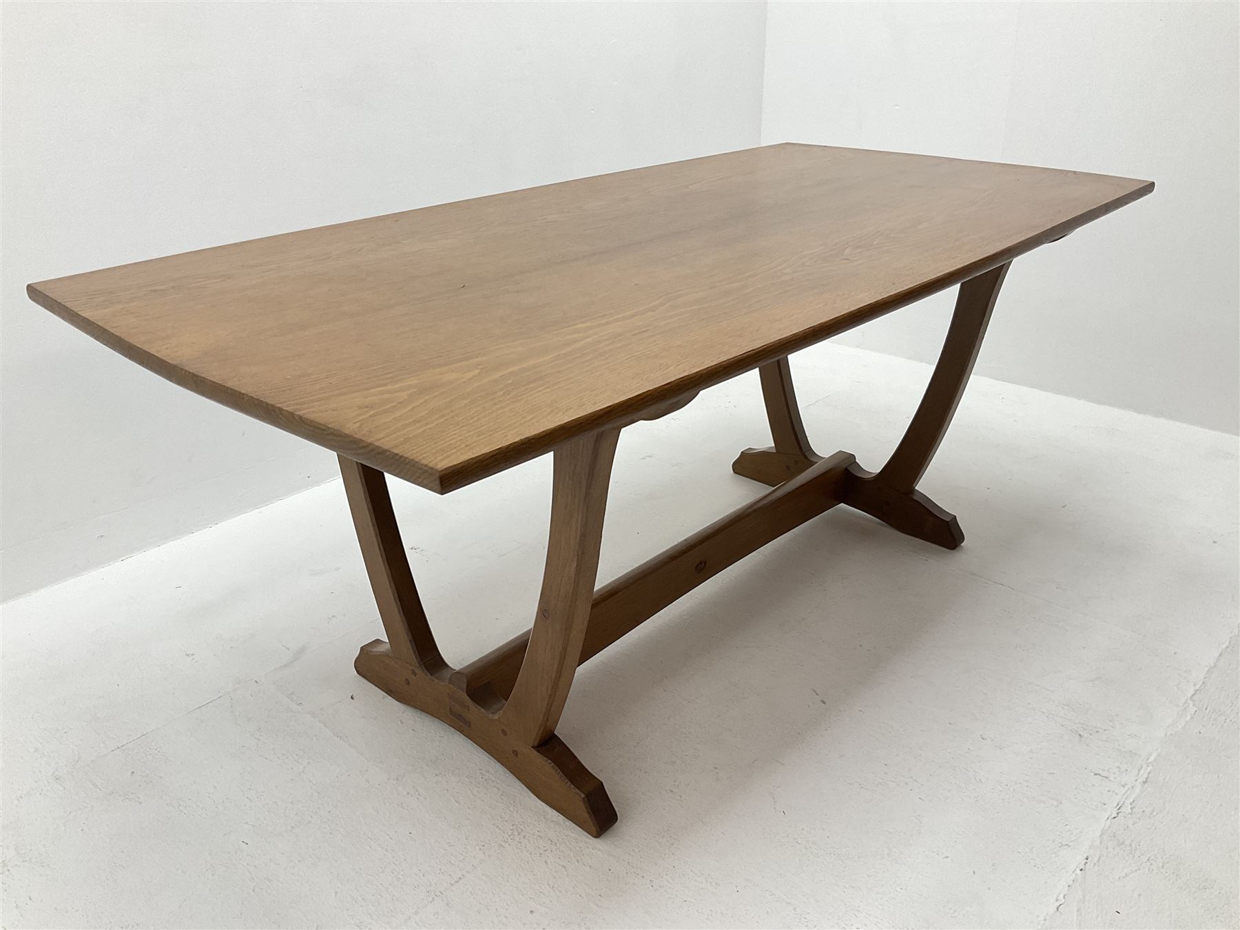 'Acornman' oak rectangular dining table, slightly curved rectangular top supported by two curved uprights, on shaped sledge feet connected by stretcher, by Alan Grainger of Brandsby, York