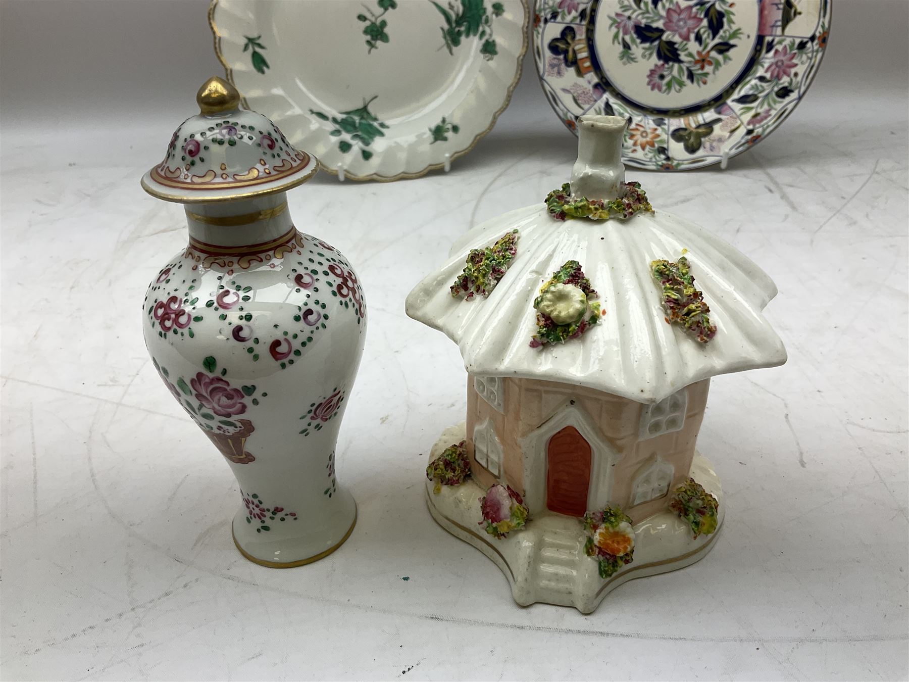 Mid 18th century Chelsea plate with gold anchor mark beneath, decorated with green floral sprays upon plain ground, the moulded cavetto shaped border with gilt rim, (A/F), D22cm, together with early 20th century Adams Tunstall Tokio pearlware slop bowl, Spode plate decorated in the Imari type pallette, with impressed and printed marks beneath, 19th century Indian Tree pattern breakfast cup and saucer, small polychrome enamelled vase and cover in the style of Samson of Paris, with marks beneath, and a pastille burner