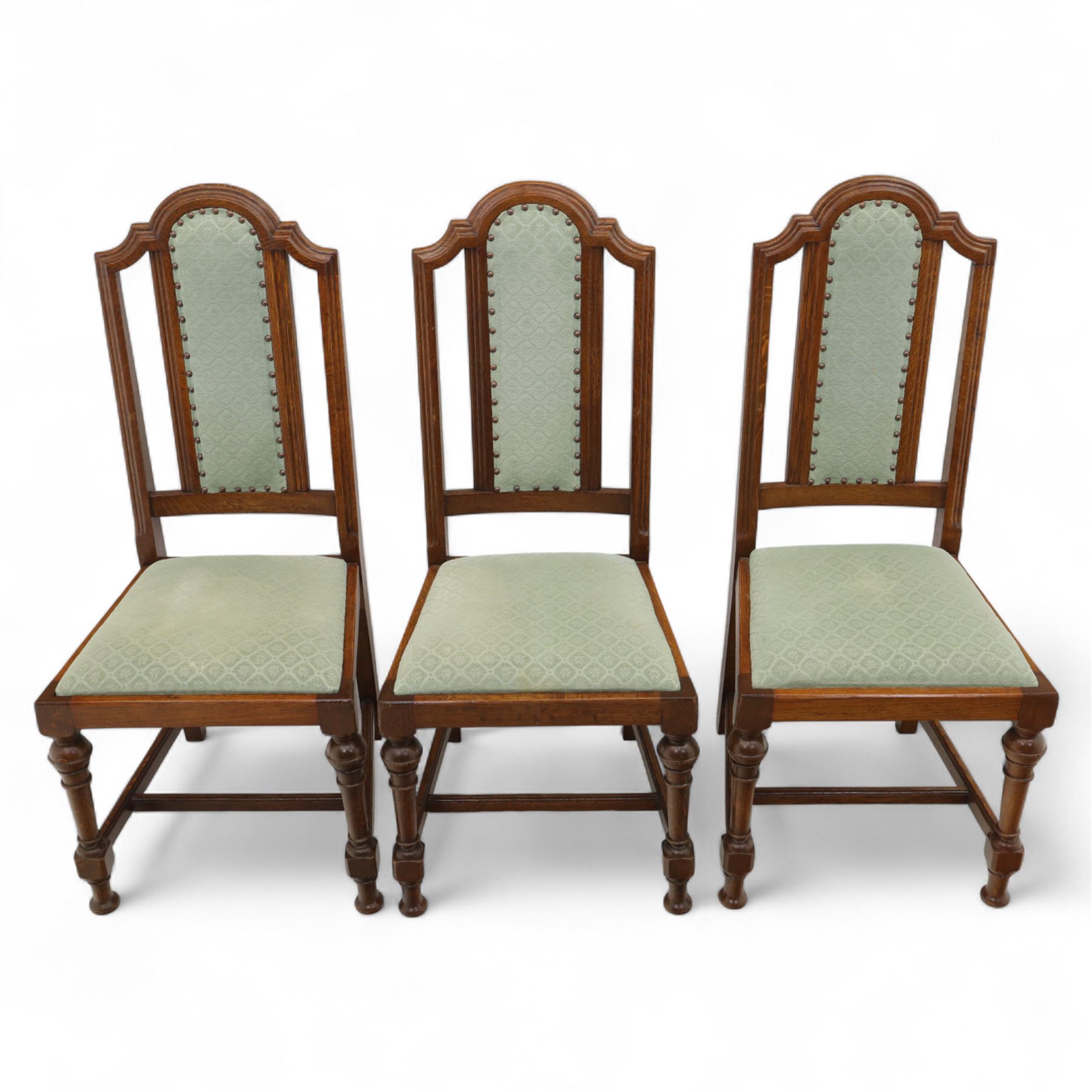 Victorian mahogany extending dining table, rectangular top with chamfered corners above a plain frieze raised on turned reeded legs with castors and two additional leaves, 197cm fully extended, and a set of six early 20th century oak upholstered chairs with drop-in seats, arched panelled back splat and close studded border on turned front legs joined by stretchers, 47x41x109cm 