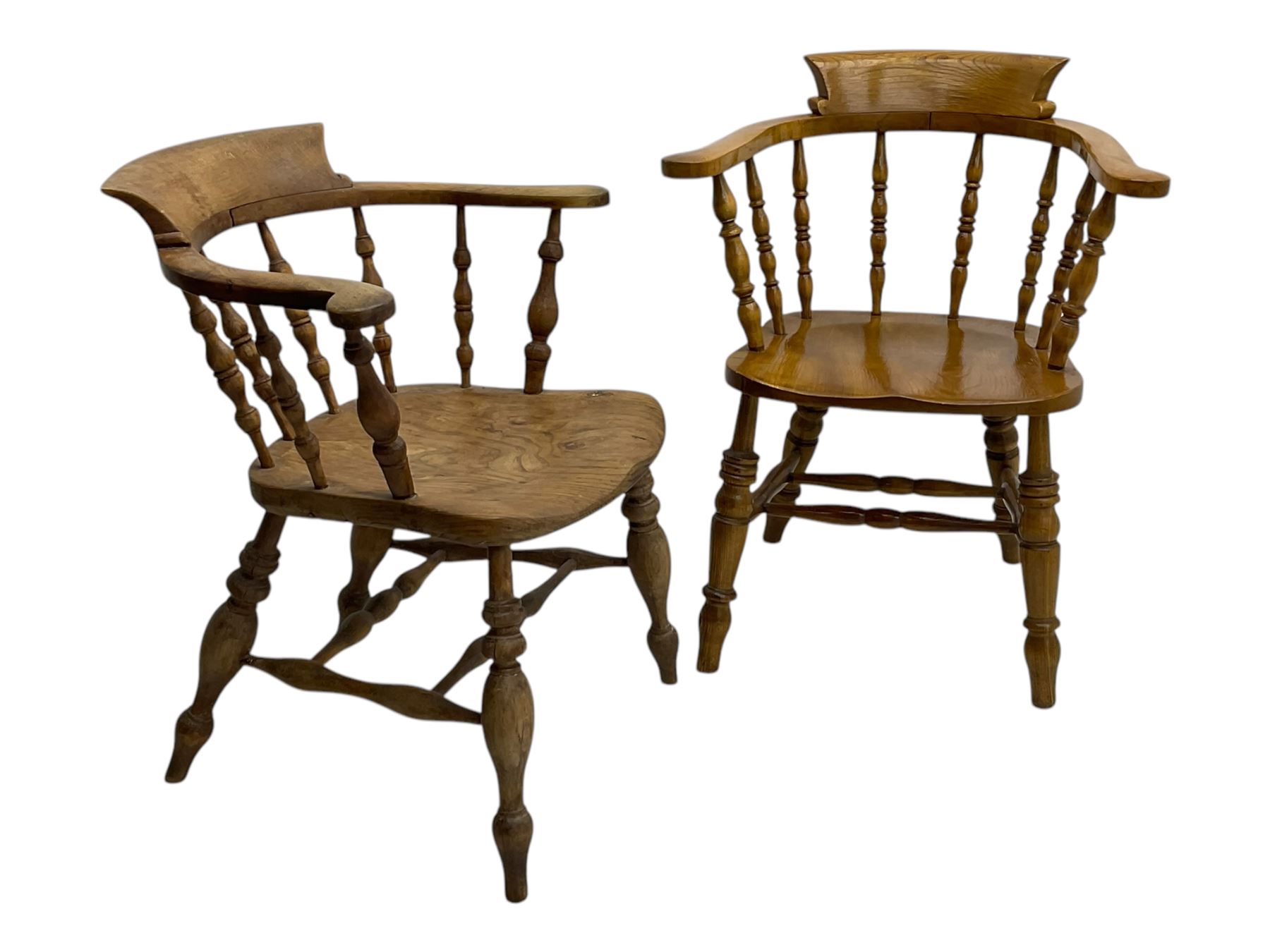 Late 19th century elm smoker’s bow armchair, curved top rails over turned spindle backs, shaped seats, raised on turned legs united by turned stretchers; together with a similar smoker’s bow armchair (2)