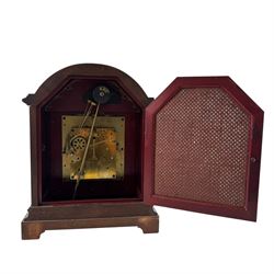 Gustav Becker, German 20th century 8-day mahogany cased mantle clock, break arch mahogany case with a round topped door flanked by reeded pilaster with Ionic capitals and raised on a stepped plinth, the dial with engraved Roman numerals, with steel fleur di Lis hands, and  chime /silent dial, H43cm