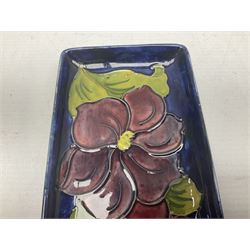 Moorcroft rectangular pin dish decorated in the Clematis pattern upon cobalt blue ground, together with a small circular footed dish decorated in the Hibiscus pattern, both with impressed marks beneath, tray L20cm (2)