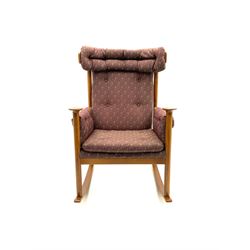 Parker Knoll teak framed rocking armchair, upholstered in buttoned patterned fabric, turned supports and shaped rocker 