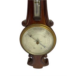 Early 20th century aneroid barometer c1910 in a scroll carved mahogany case with a silvered dial, brass bezel and flat glass, reading barometric pressure from 28-31 inches with weather predictions, steel indicating hand and brass recording hand, with a surface mounted boxed mercury thermometer recording the ambient temperature in degrees Fahrenheit.   
