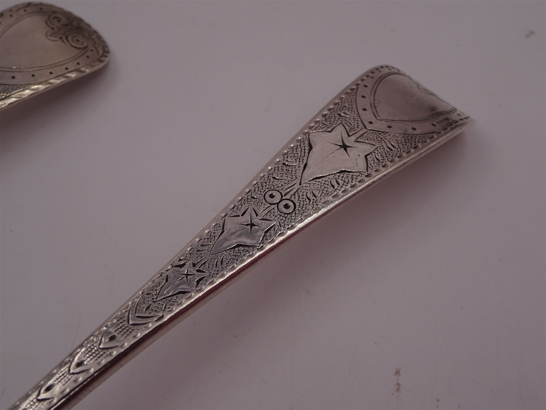 George IV silver fruit serving spoon, the bowl embossed with fruits, with engraved vine leaf decoration to handle, hallmarked London 1789, together with a very similar earlier example, hallmarks worn and indistinct