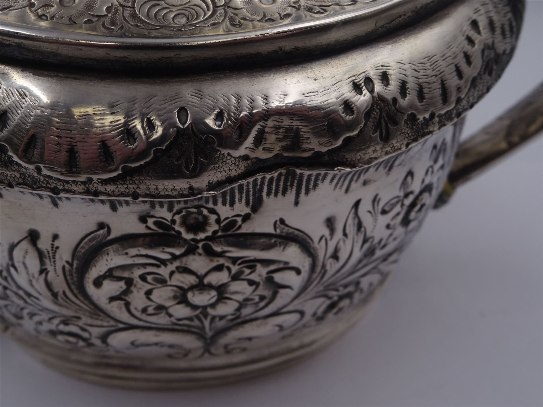 George III silver teapot, of oval form, with embossed foliate, floral and scroll decoration and engraved central cartouche, with acanthus capped C handle with ivory insulators, hallmarked John Emes, London 1807 This item has been registered for sale under Section 10 of the APHA Ivory Act
