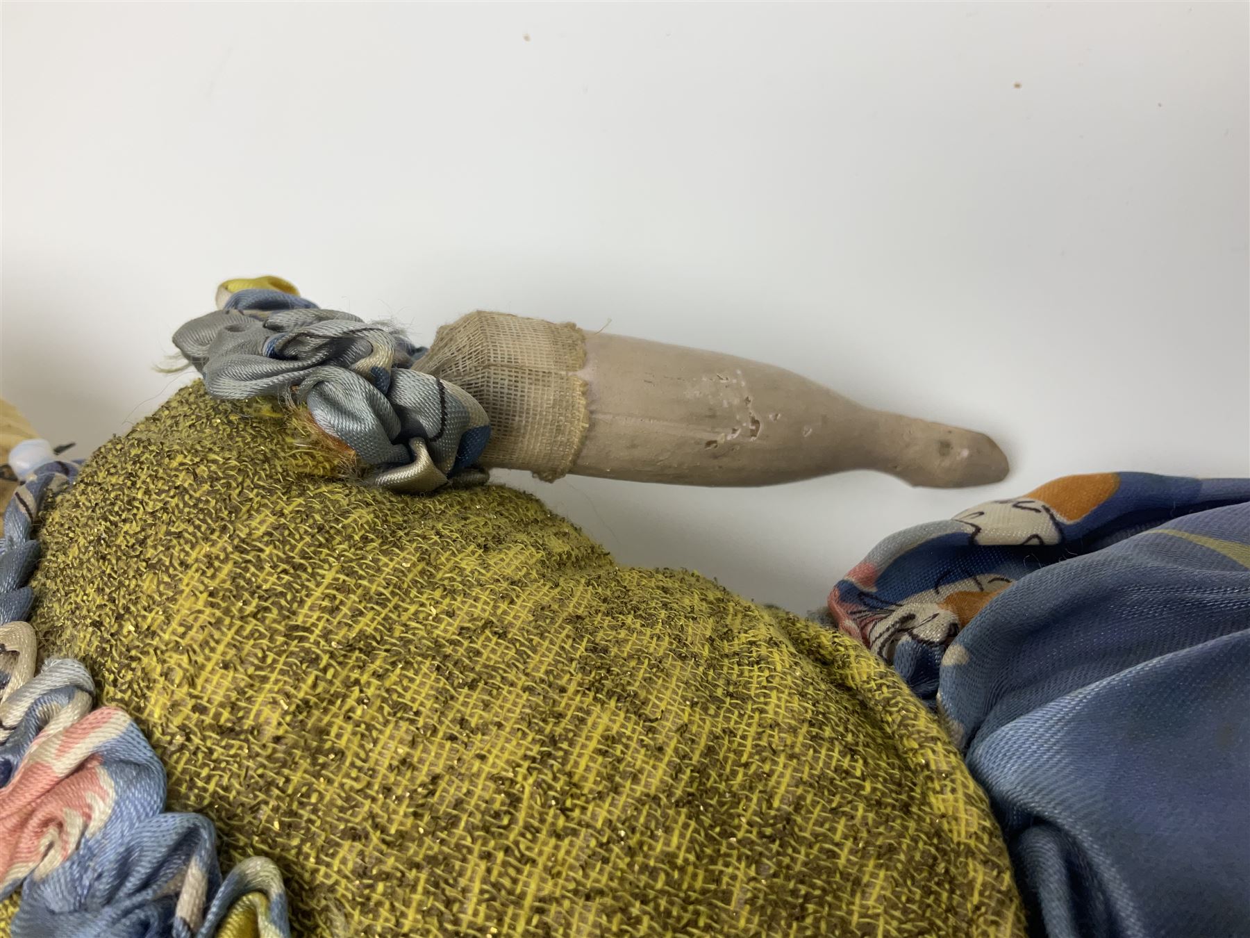 Victorian large wax over composition Pumpkin head doll, with inset dark glass eyes, moulded blonde hair in curls, stuffed body with carved and painted wooden limbs, grey painted boots, floral satin dress with netting underclothes H61cm
