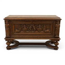 Carved oak coffer bench, rectangular moulded top above carved fall front, with figural, ma...