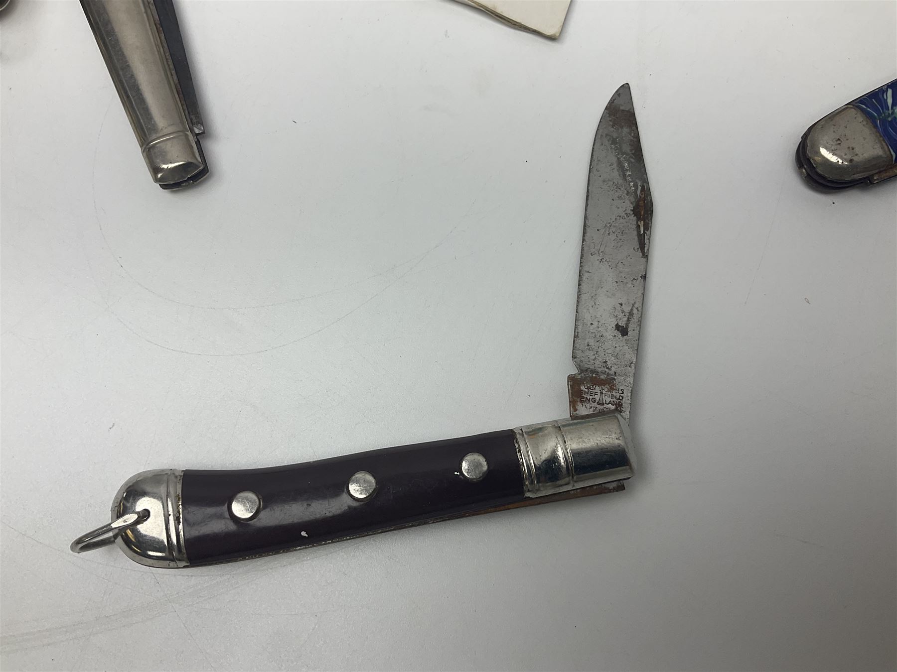 Seven pen knives, two lighters, including one Ronson example and a collection of postcards