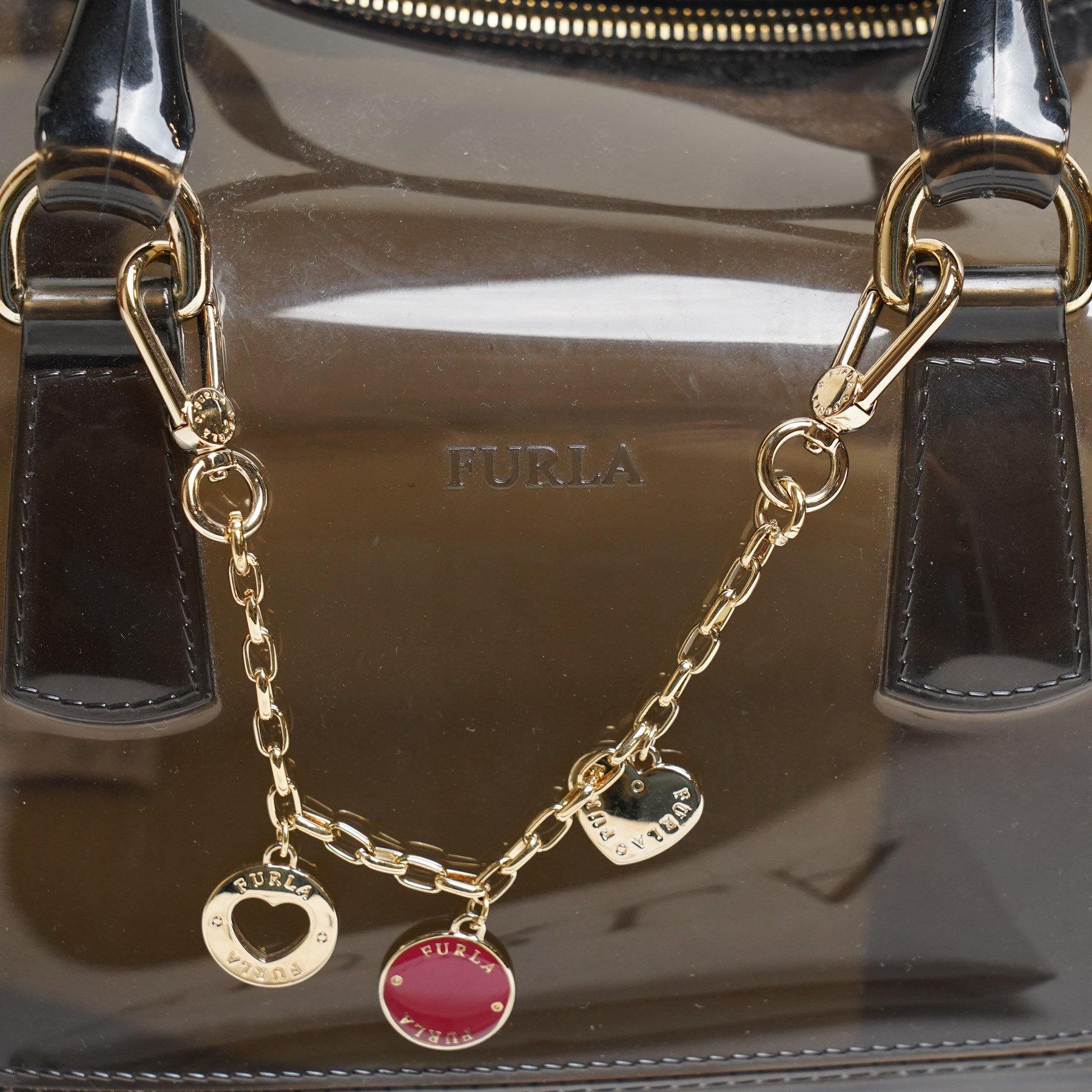 Furla - ‘Candy’ top-handle bag in smoky black transparent PVC, with rolled top handles, gold-tone hardware padlock, with front-hanging charm chain, with original Furla dust bag