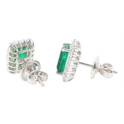 Pair of 18ct white gold emerald and diamond cluster earrings, each stud set with a single octagonal cut emerald, with round brilliant cut diamond surround, stamped, total emerald weight approx 3.00 carat