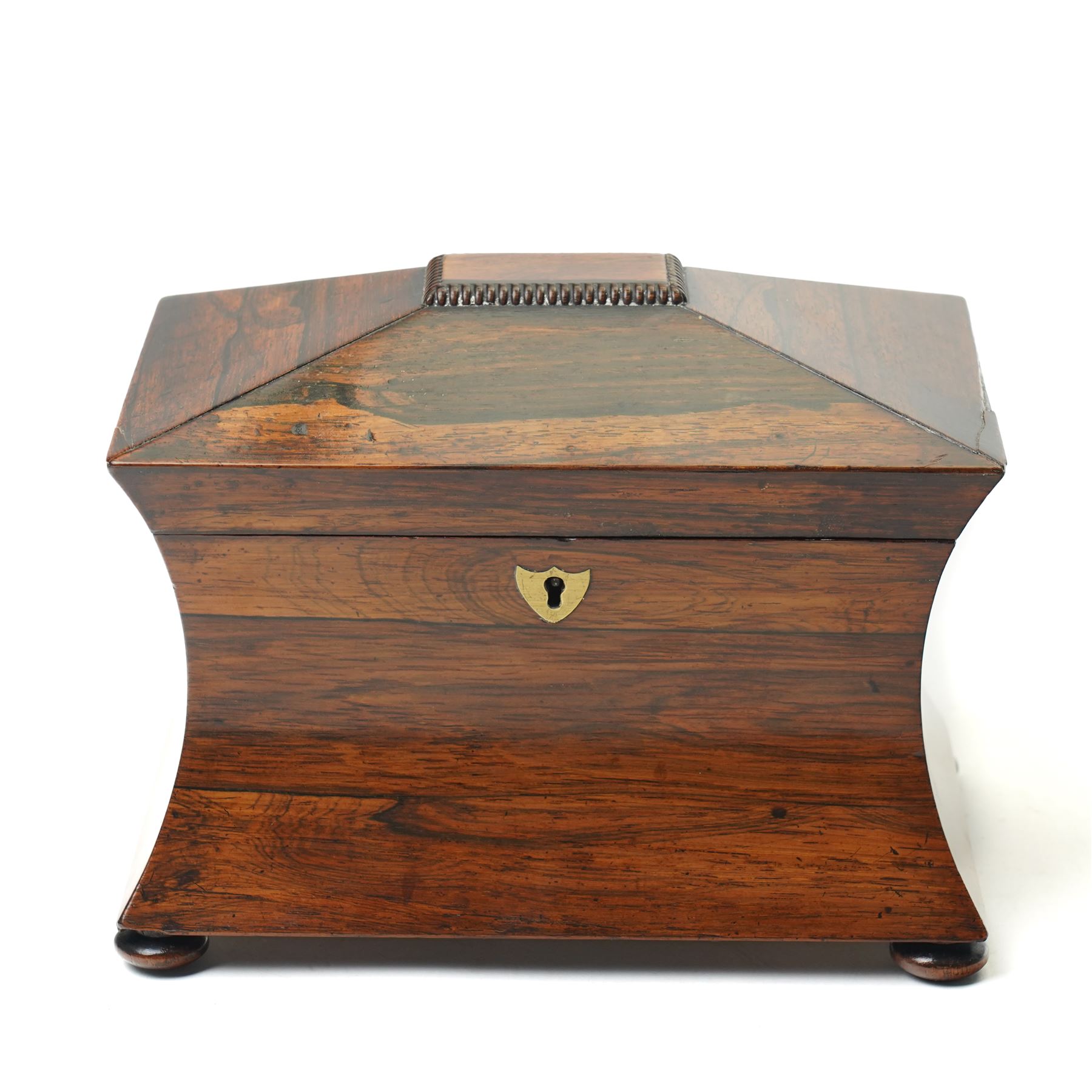 Early 19th century rosewood tea caddy of waisted sarcophagus form, twin compartments, on compressed bun feet, brass keyplate, H17cm W22cm 