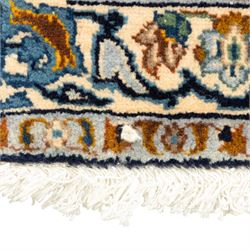 Persian Kashan rug, cream ground decorated with an all-over pattern of interlaced floral stems, rosettes and palmettes in blue, gold and rust tones, framed by layered floral borders, woven in the Kashan region of Iran