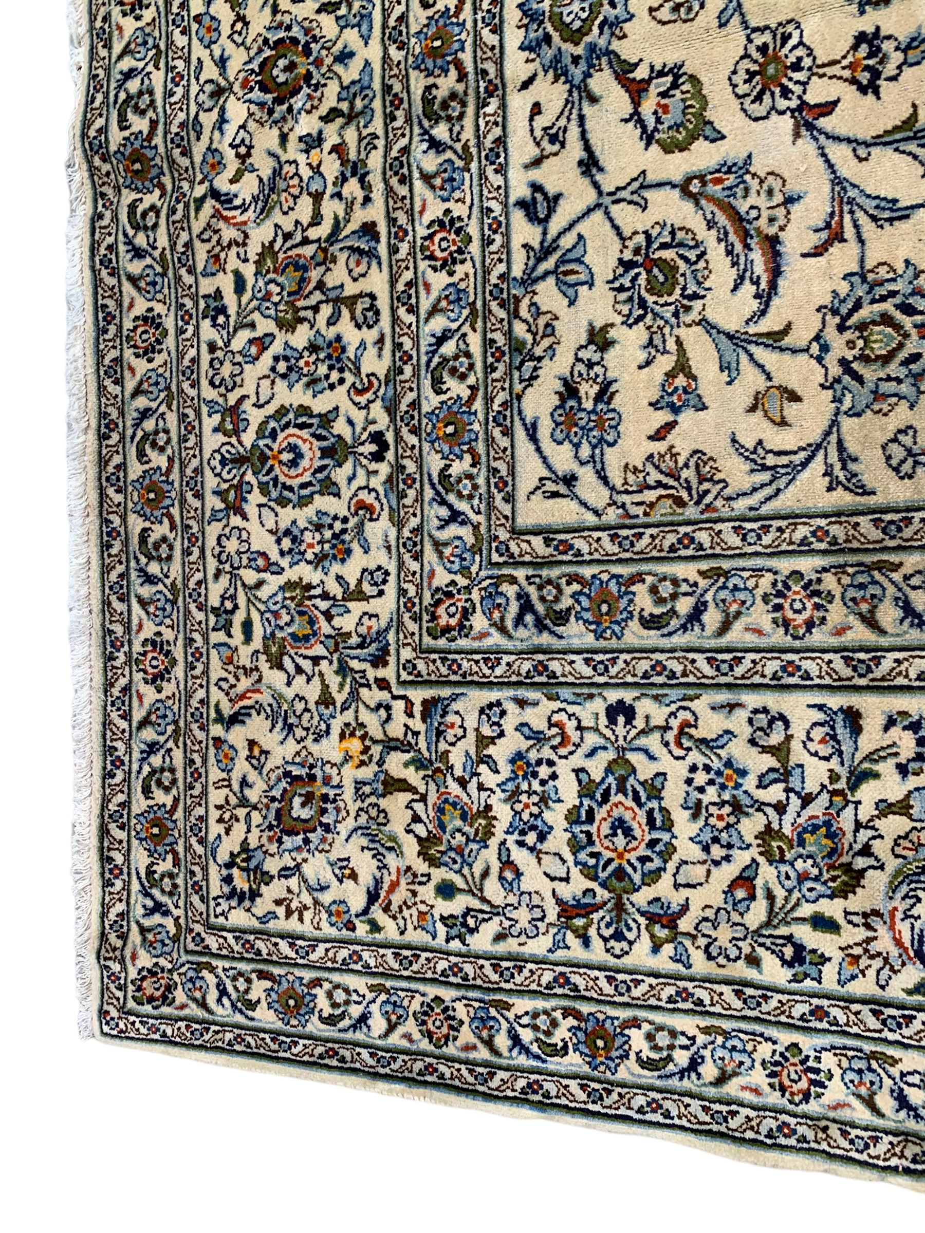 Persian Kashan ivory ground carpet, the field decorated with interlacing leafy branches and stylised plant motifs, repeating border with multiple guards