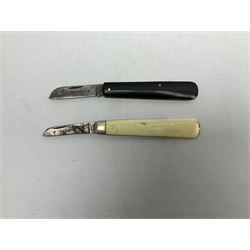 Two Saynor folding knives, comprising a bone handled budding knife and a black handled example, both with blades stamped Saynor Sheffield, largest L16cm