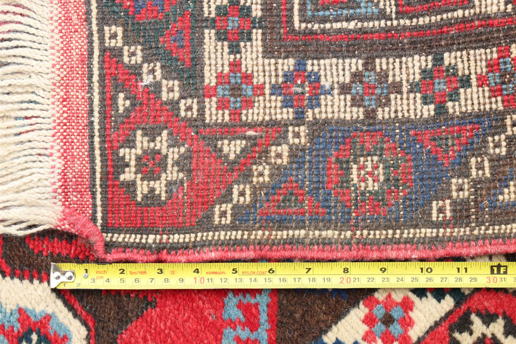 Two Persian rugs, Persian Hamadan hand-knotted rug, ivory ground centred by a terracotta medallion, surrounded by scrolling floral and foliate motifs, dark navy floral border with narrow guard stripes, fringed ends, H 176cm, W 75cm, Persian tribal hand-knotted rug, madder red ground decorated with three large geometric medallions, surrounded by angular motifs, enclosed by multiple geometric borders in dark navy, ivory and red, fringed ends, H 150cm, W 91cm