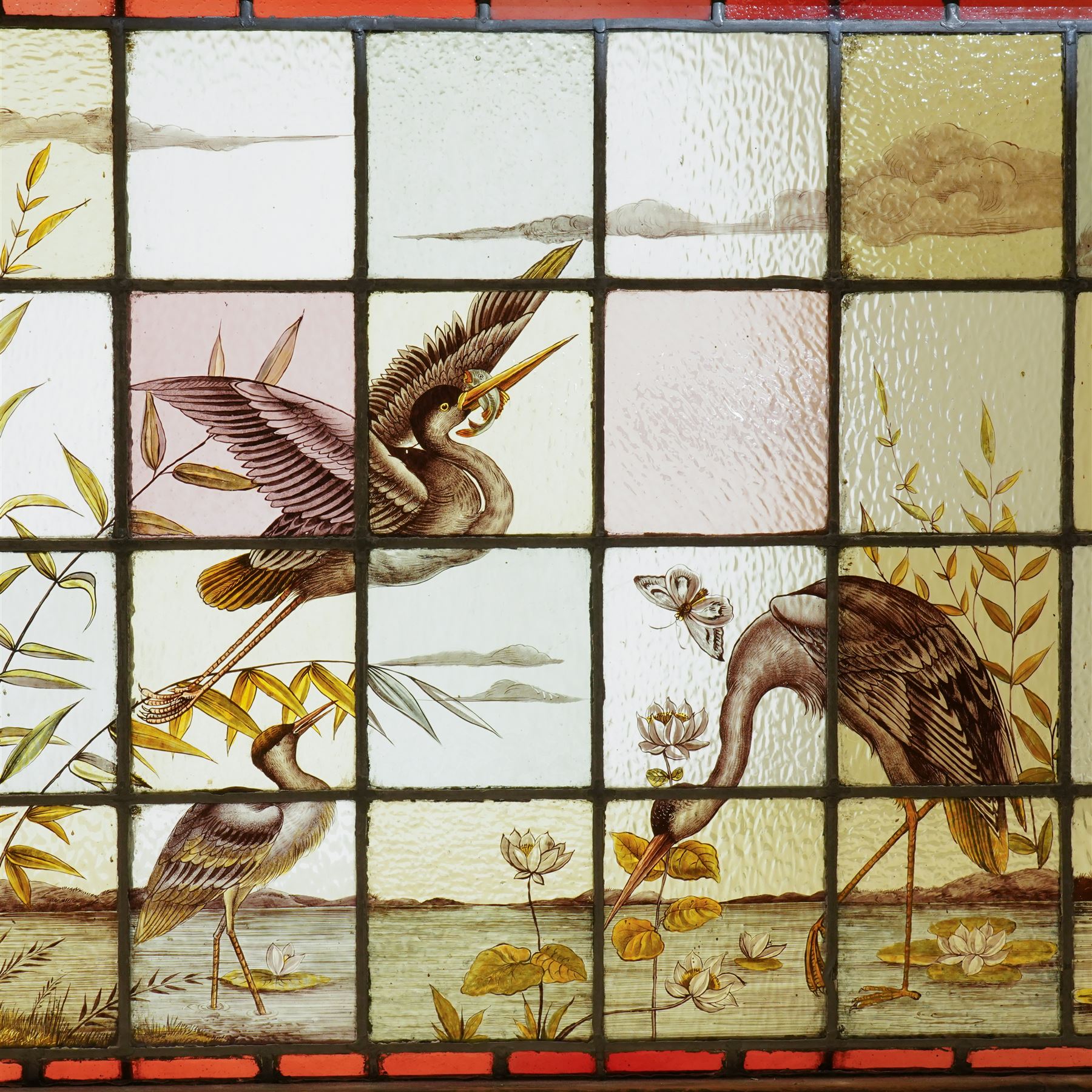 Large Victorian Aesthetic movement stained glass leadlight window panel, hand painted with a scene of herons and other birds in a lake, overall 82cm x 147cm 