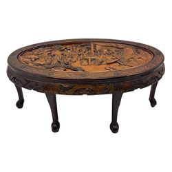 Early 20th century Chinese hardwood nesting coffee table, oval top carved with figures and traditional pagoda scenes with carved frieze, complete with six inset stools or side tables, raised on tapering supports with paw feet