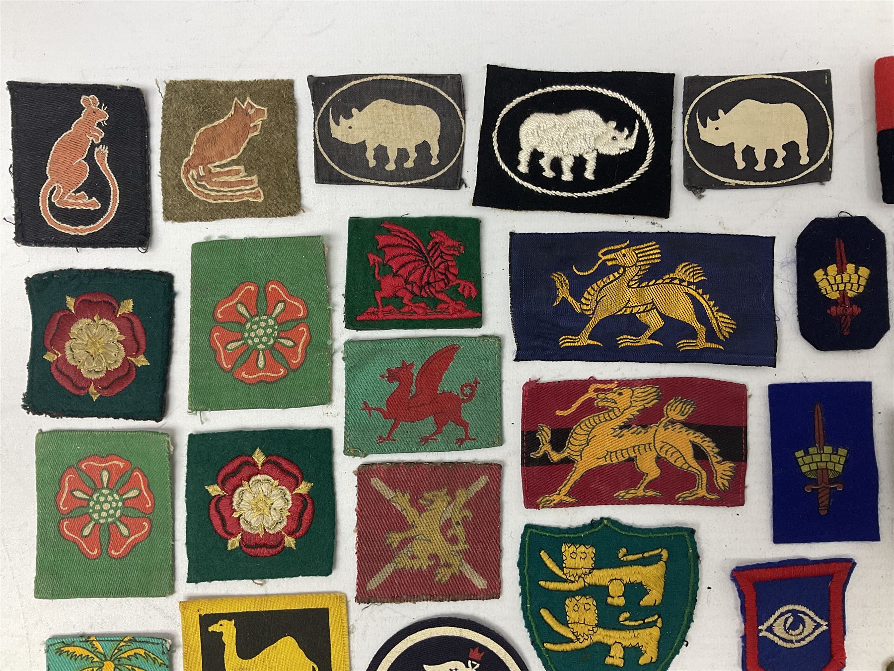 Approximately one-hundred printed and embroidered cloth badges including Royal Tank Regiment, Royal Armoured Corps, 219th Independent Infantry Brigade, Cyrenaica, Cyprus, Singapore and other districts, Gibraltar Garrison, East Anglian Brigade, 20th Armoured Brigade and various armoured divisions etc