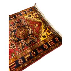 Persian Heriz golden red ground runner, the field decorated with five medallions and geometric motifs, repeating geometric design guarded boarder 