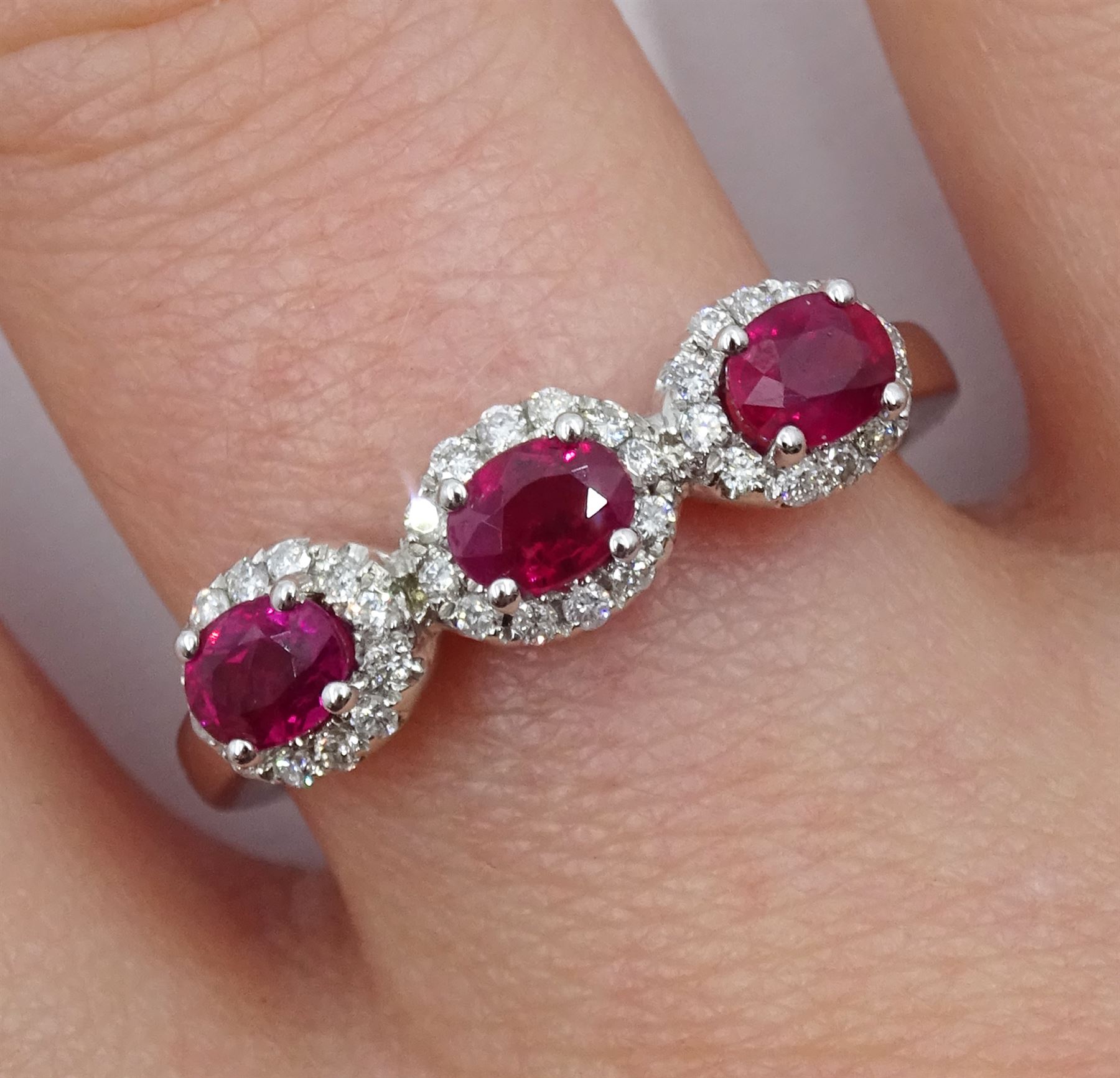 White gold three stone oval ruby and round brilliant cut diamond cluster ring, hallmarked