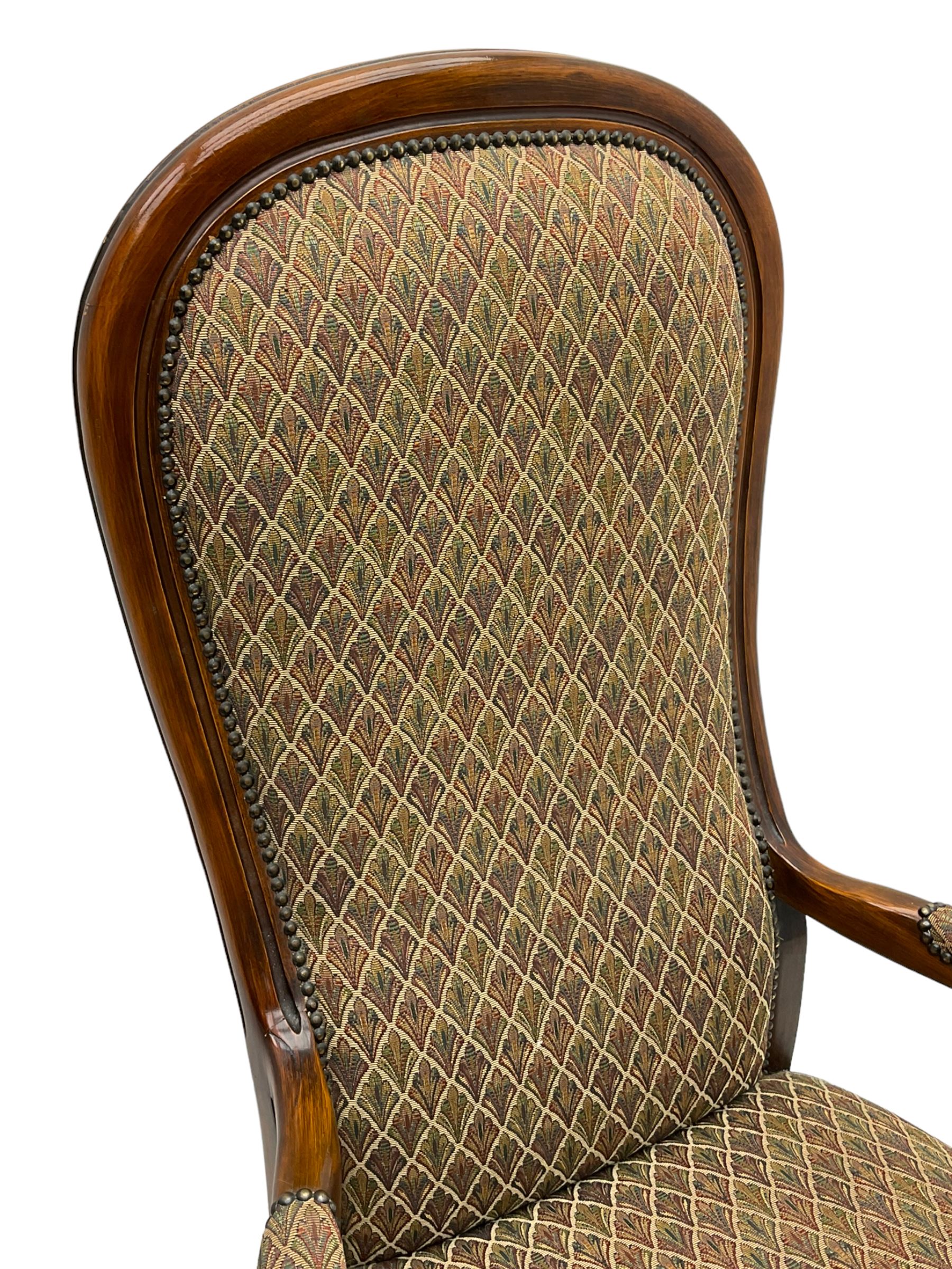 Stained beech framed open armchair, upholstered in foliate pattern fabric, on cabriole front supports