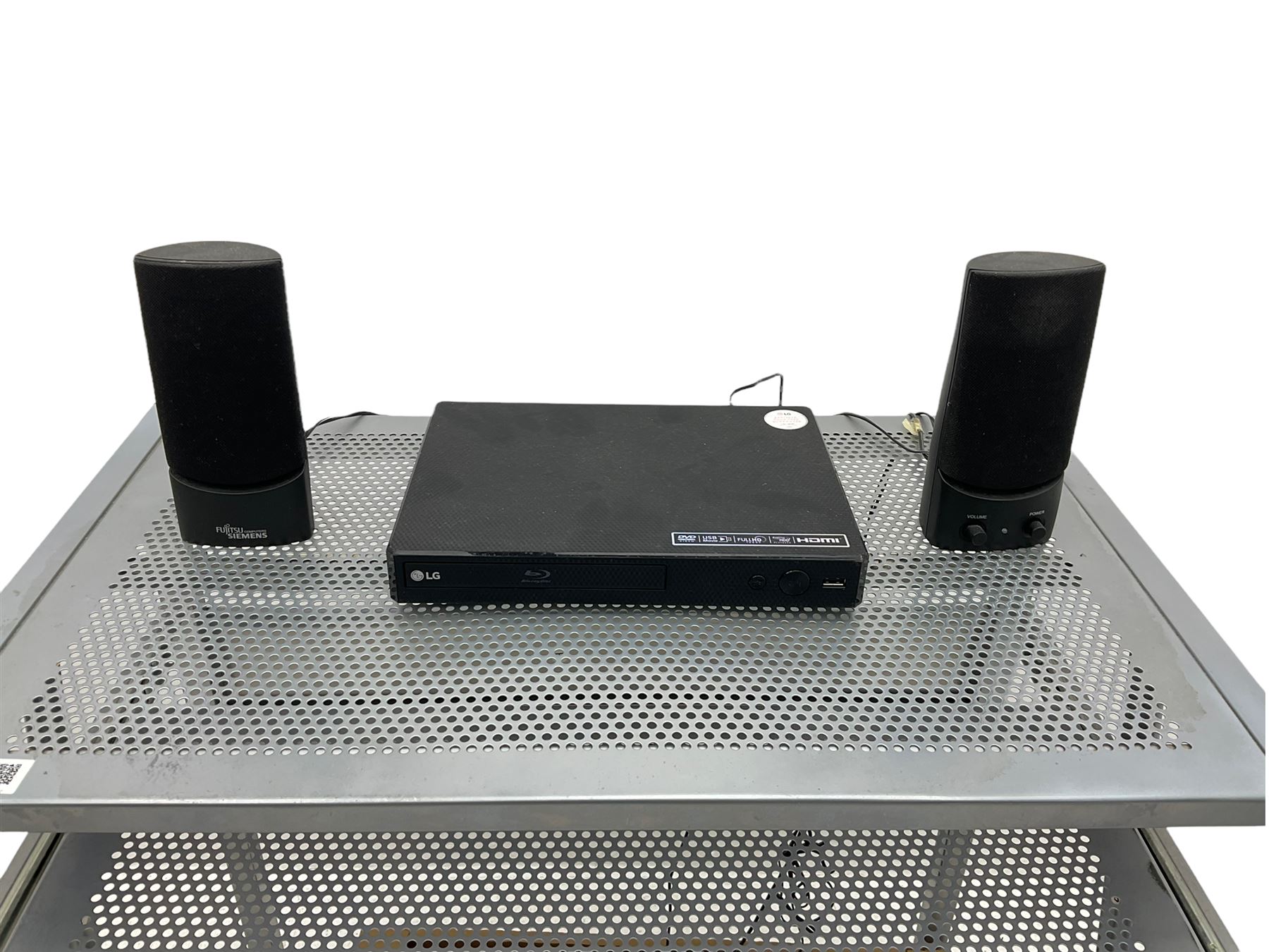 LG BP250 Blu-ray player, Sony floppy disk drive, pair Fujitsu speakers and various cables on computer stand