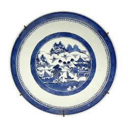 19th century Chinese export blue and white charger, decorated with waterside landscape set with pagodas, huts, bridge, fishing vessels and willow and pine trees, within trellis borders, the underside rim decorated with bamboo fronds, D38cm