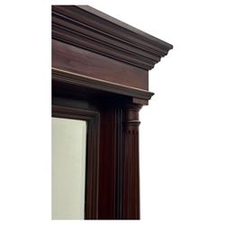 Victorian mirror back press, the arched corniced mirror back flanked by half columns, the base fitted with three drawers and four moulded panel doors with geometric detail, on a block plinth
