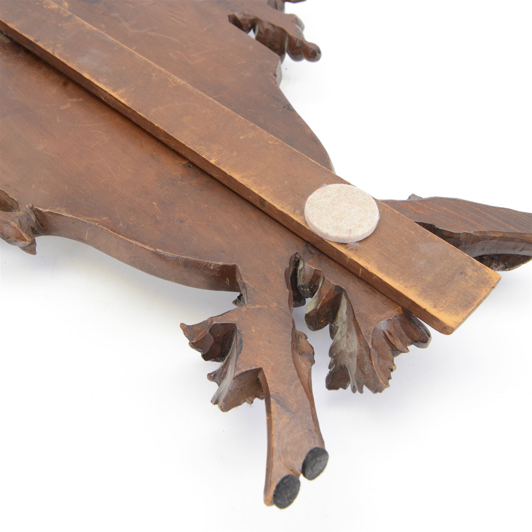 Late 19th century Continental carved wooden easel mirror, probably Black Forest, the shaped and bevelled mirror plate with surround carved with fruiting vines and surmounted with the figure of a cherub, with easel support verso, H72cm