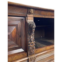 Late 17th century Flemish/Dutch rosewood and oak ‘Zeeuwse Kast’ or cupboard, projecting cornice carved with three putti masks, the uprights carved with lion masks over ribbons, flower heads and foliage, enclosed by four geometric panelled doors, lower central upright carved with flower head over foliate ribbon with bird among foliage, the escutcheon hidden by swivel berry carved cover, interior fitted with shelves, two drawers and shallow hinged cupboard, on two large turned and ebonised feet, circa 1680