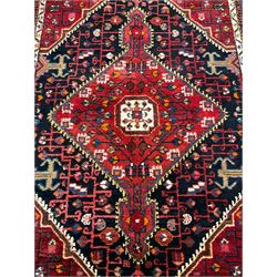 Persian Hamadan red and indigo ground rug, central lozenge medallion with extending poles, the field decorated with interlaced branches and flowerheads, guarded border with stylised floral motifs