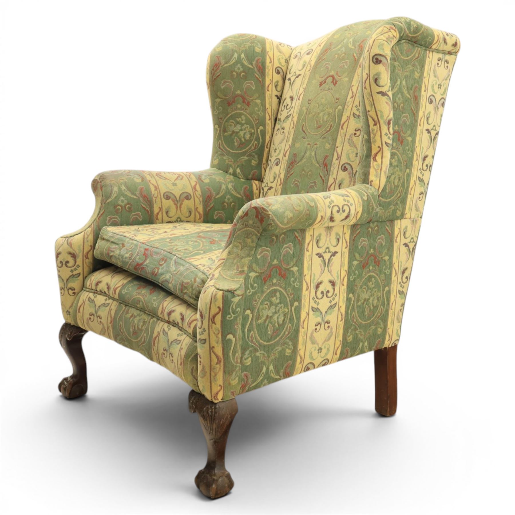 Queen Anne style wingback armchair, upholstered in green and cream foliate fabric, shaped arms on ball and claw feet