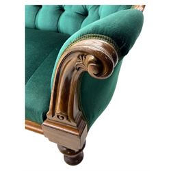 Victorian mahogany settee, upholstered in green buttoned fabric, moulded frame and scroll carved arm terminals, turned supports on castors