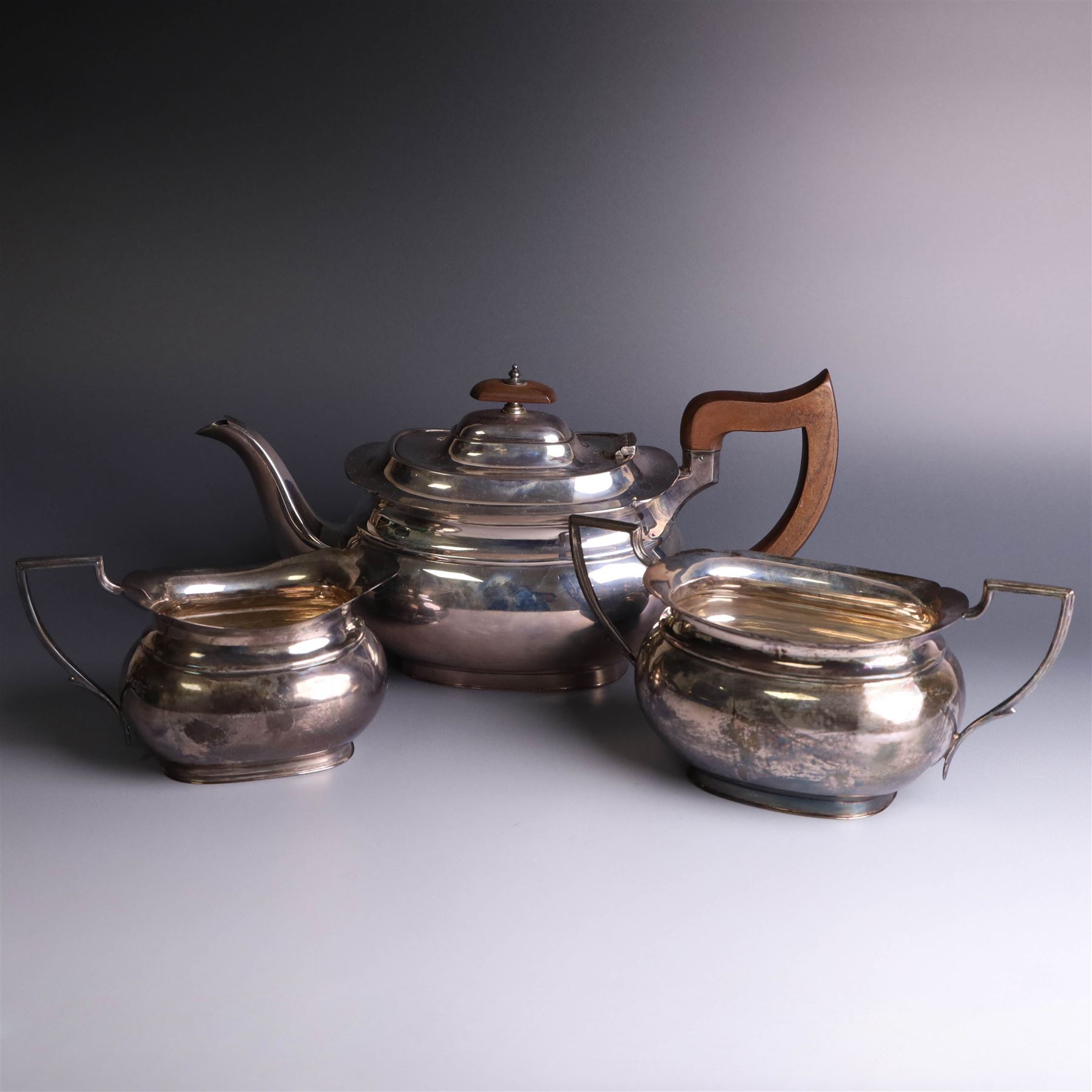 1930s three piece silver tea service, comprising teapot with wooden handle and finial, open sucrier and milk jug, hallmarked Viners Ltd, Sheffield 1930
