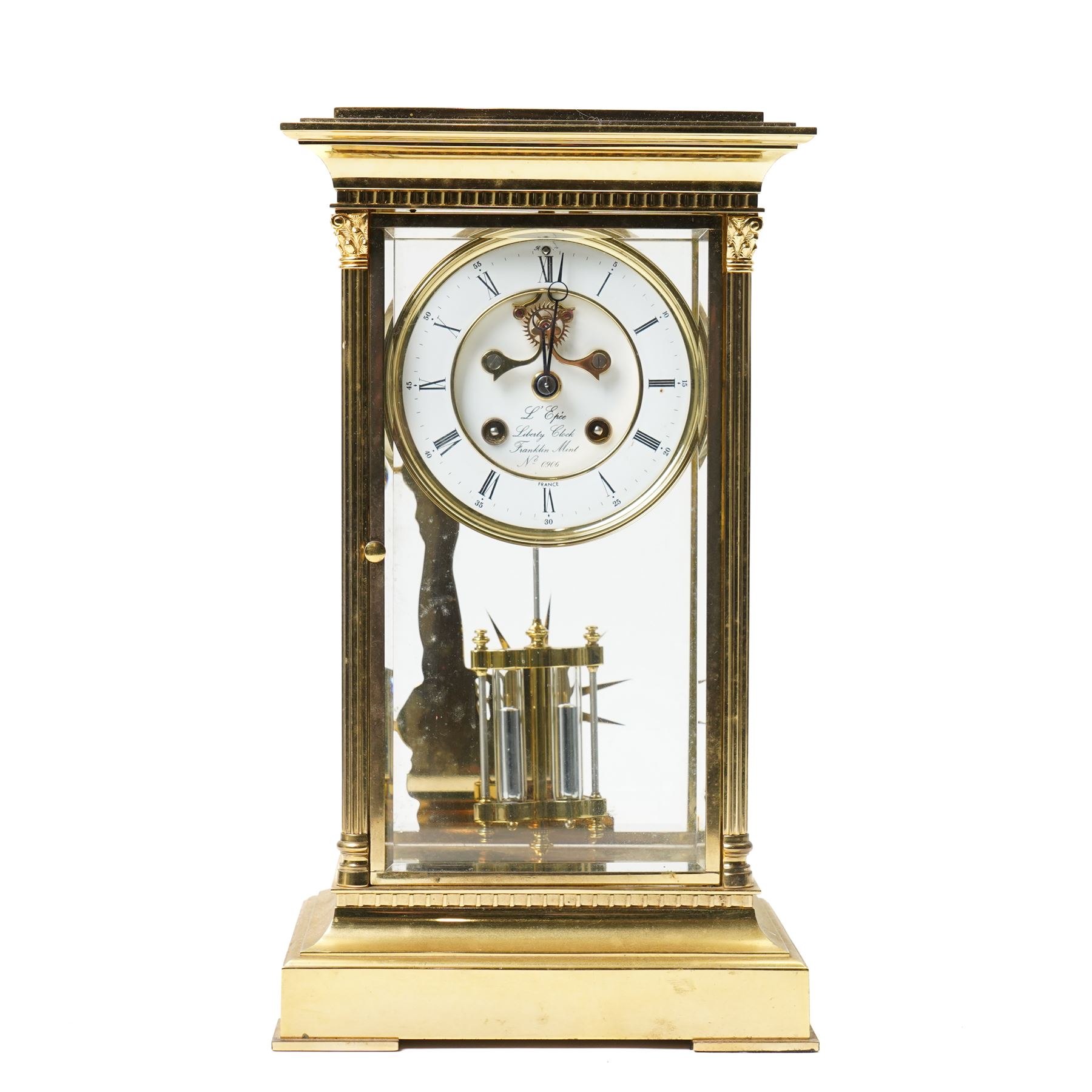 American-20th century Franklin Mint  8-day four-glass mantle clock, brass case with bevelled glass to the doors and sides, with reeded columns and Corinthian capitals to the corners, enamel dial with Roman numerals and five minute Arabic's, with steel moon hands and visible jewelled Brocot escapement, Dial inscribed L' Epee, Liberty Clock, Franklin Mint. No 0906 , with a twin file mercury pendulum and brass silhouette depiction of the Statue of Liberty to the rear of the case, twin train going barrel movement with rack striking.