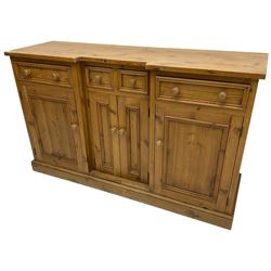 Waxed pine breakfront dresser, fitted with an assortment of four drawers and four cupboards, on skirted base