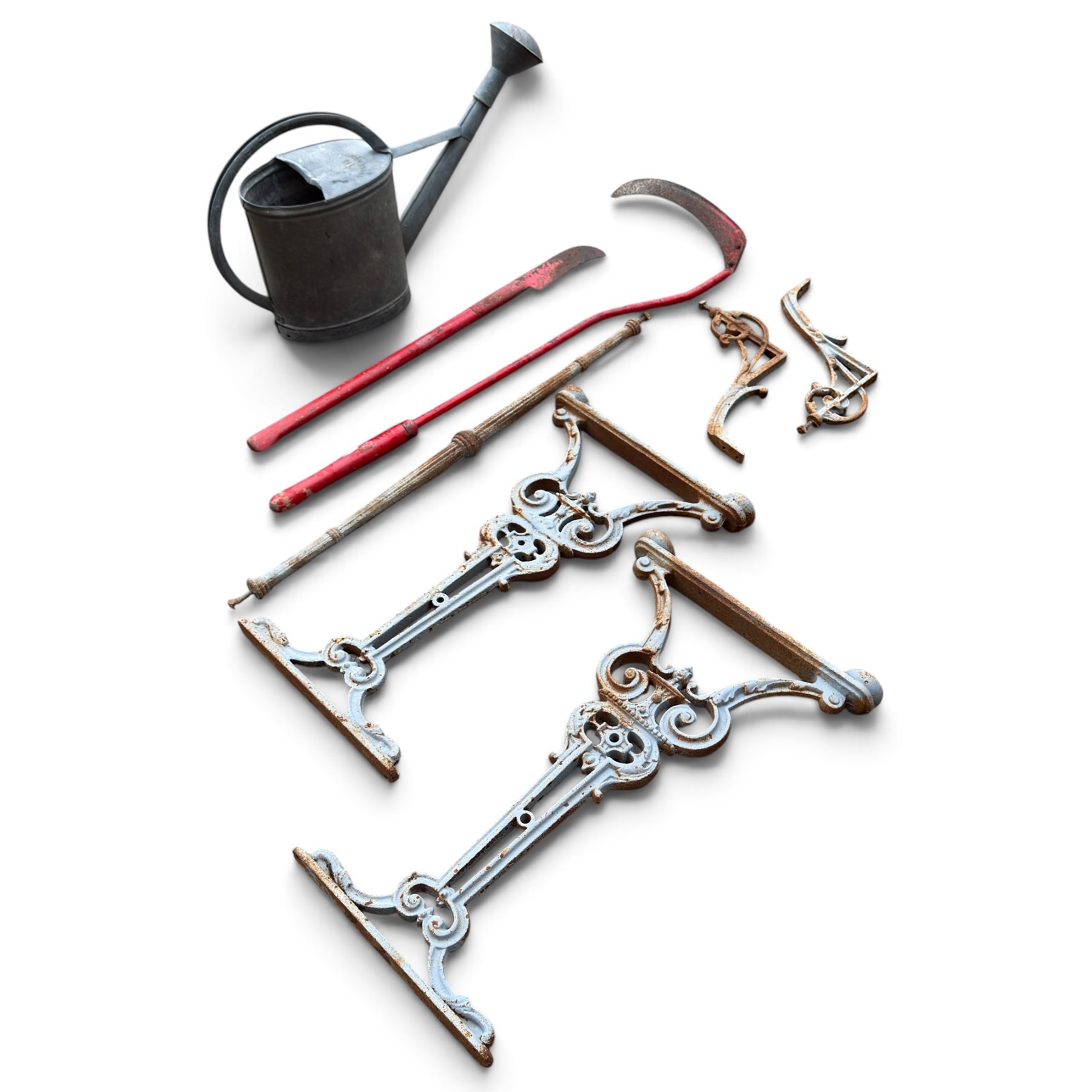 Assorted garden and architectural salvage, comprising a galvanised watering can, two long-handled cutting tools, metal pole, pair of ornate cast iron supports and further decorative fragments