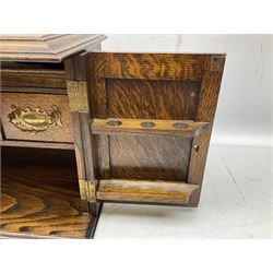 Early 20th century oak smokers cabinet, with twin twin drop handles to sides, hinged lift up top and twin doors to front carved with foliate panels, opening to reveal a compartmented interior, H27.5cm W38cm D21.5cm