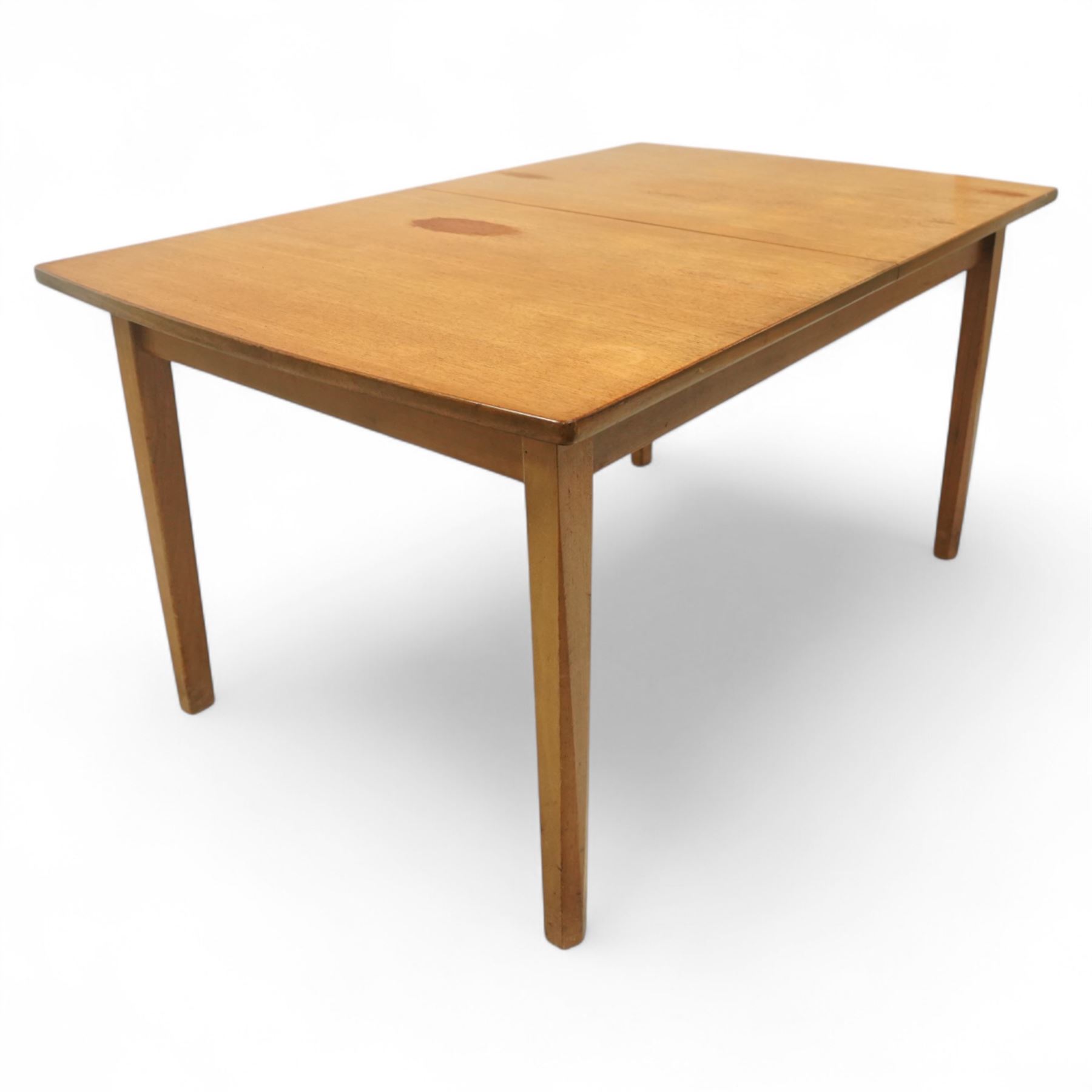 Mid-century Dutch teak extending dining table, rectangular top with lightly chamfered edge incorporating a pull-out extension leaf stowed on the underside, above a plain apron and raised on four square tapering chamfered legs, unextended length 140cm