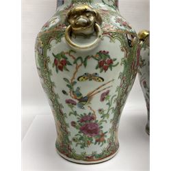 Pair of 19th century Chinese Famille Rose vases and covers, each of baluster form with twin gilt lion mask ring handles to shoulders, the flattened domed covers with gilt temple lion finials, each decorated with alternating reserves of bijin and attendants, and birds and butterflies amongst blossoming peonies, against a gilt ground profusely decorated with stylised scrolls, H32.5cm